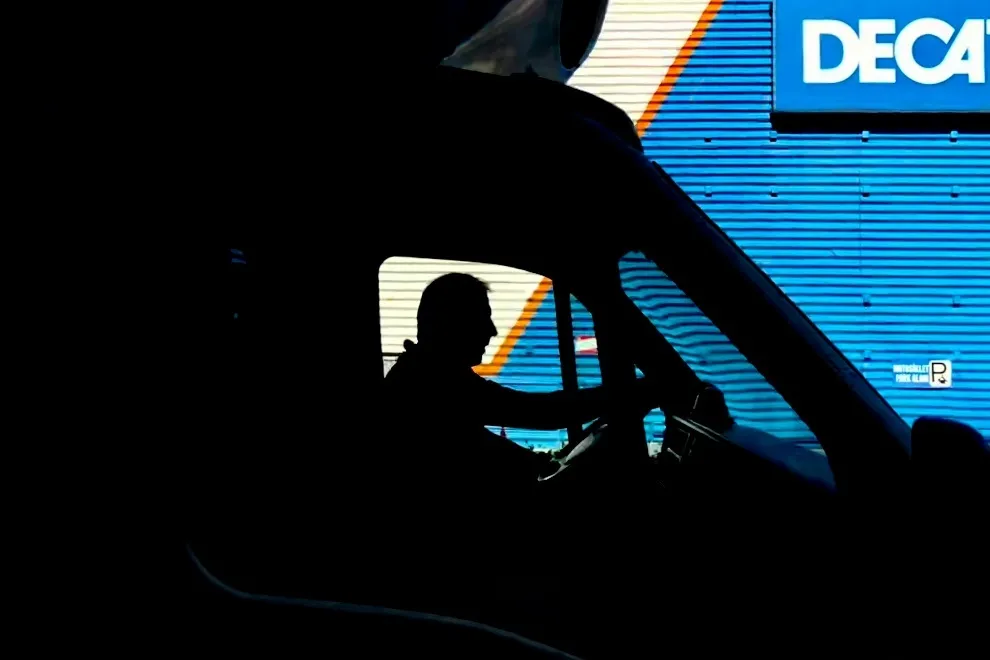 Silhouette of a man sitting at the steering in a huge truck