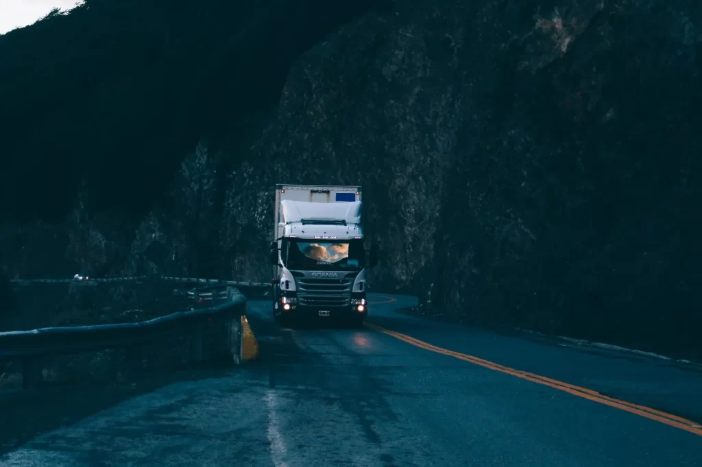 A truck on a wet road in the evening