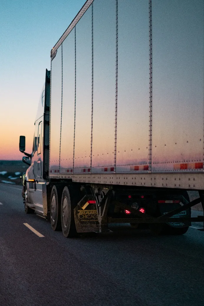 A CDL graduate driving truck on highway during daytime