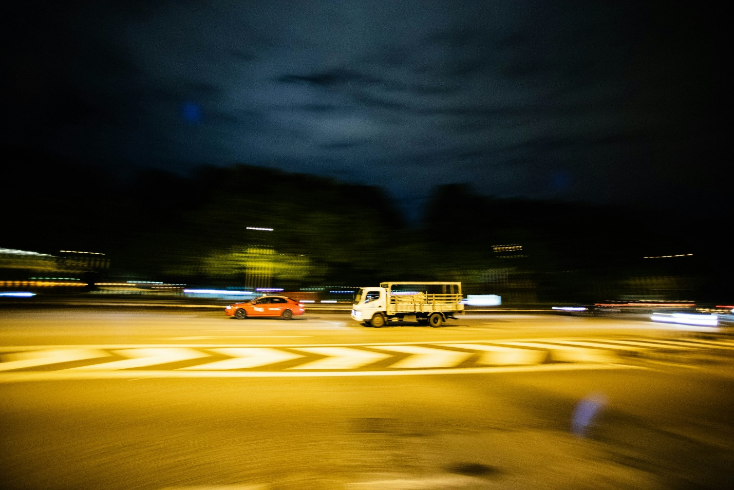 A commercial truck driving after a private car.