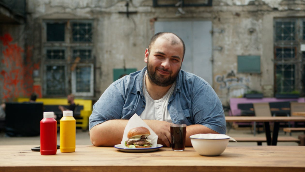 A truck driver eating a junk meal outside