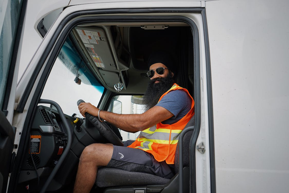 A bearded CDL truck driver in their seat