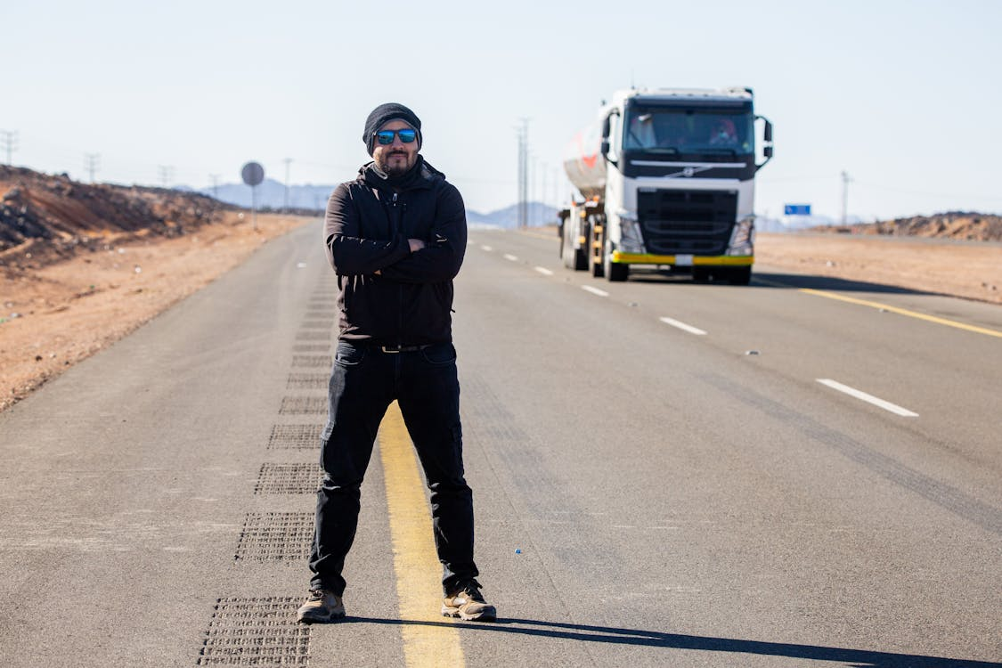 A CDL instructor on the road with a truck behind them