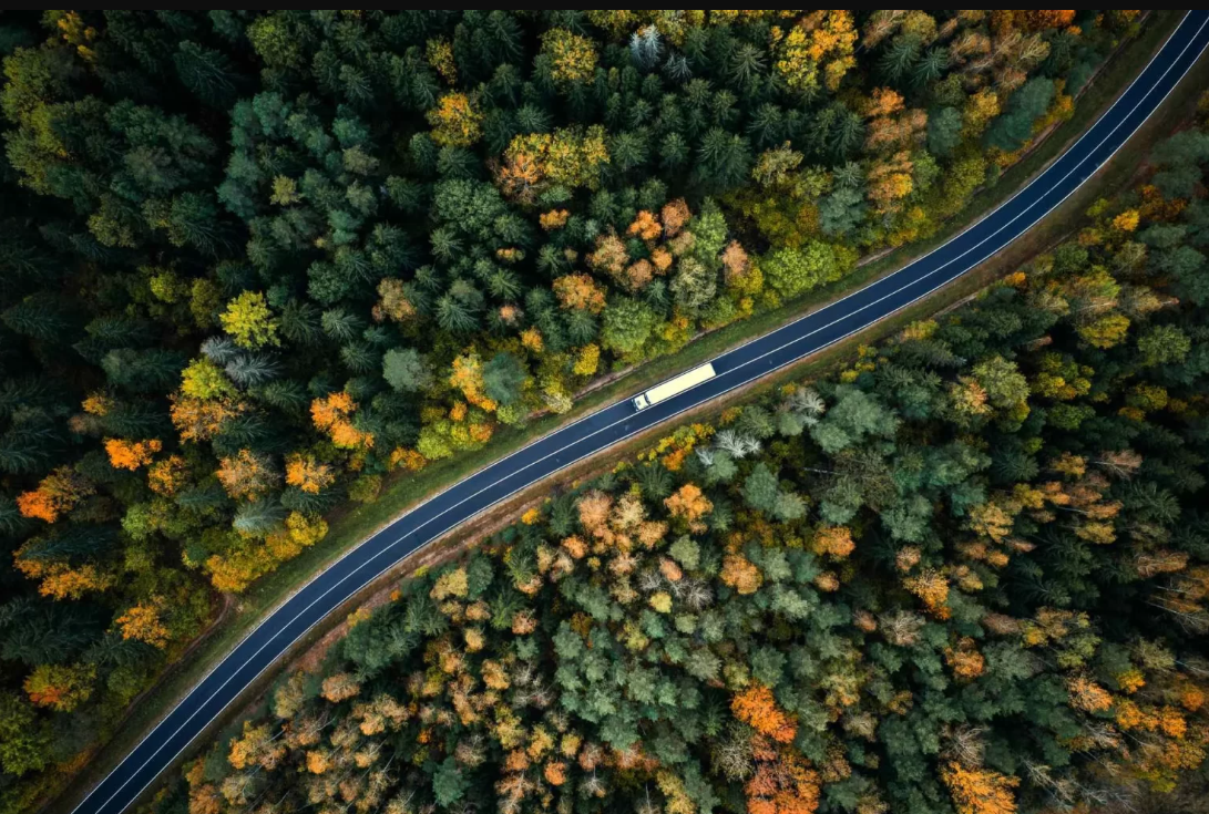 A large space with trucks and a highway road.