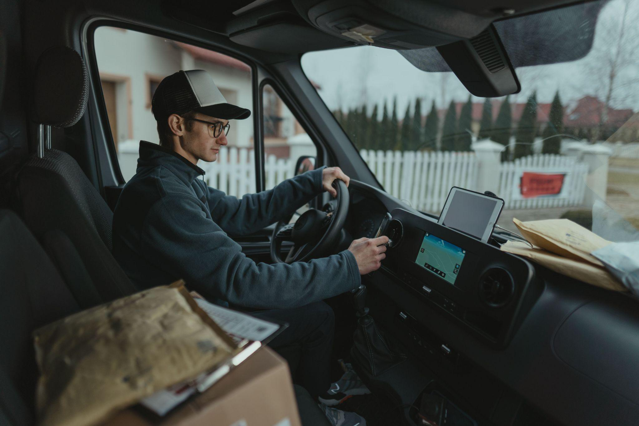 a person driving a courier truck with packages