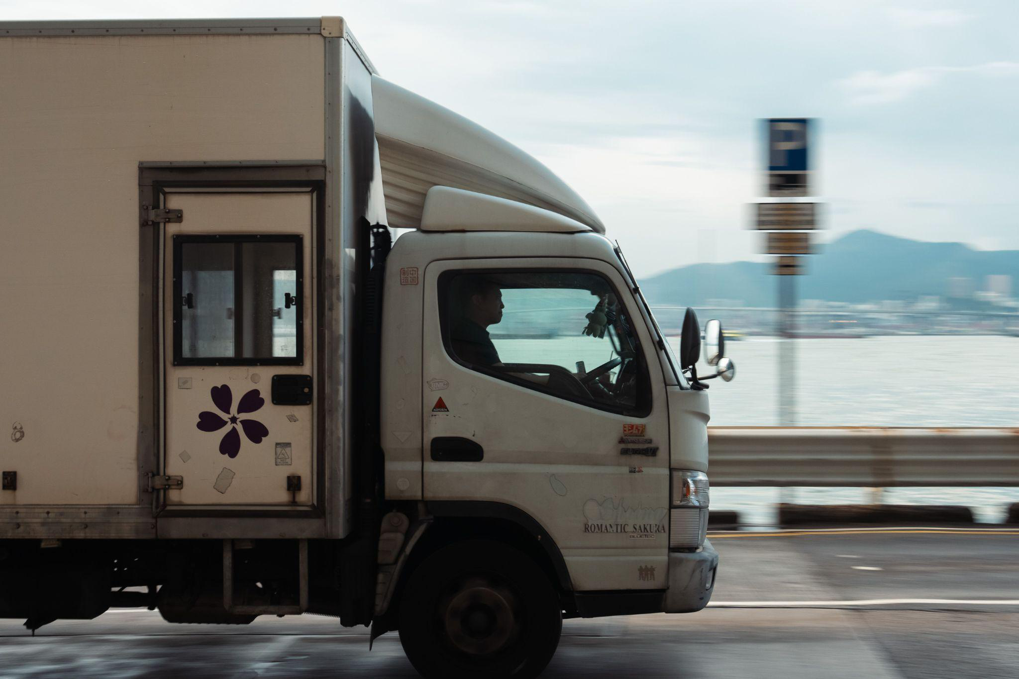 A commercial truck driving by on a road