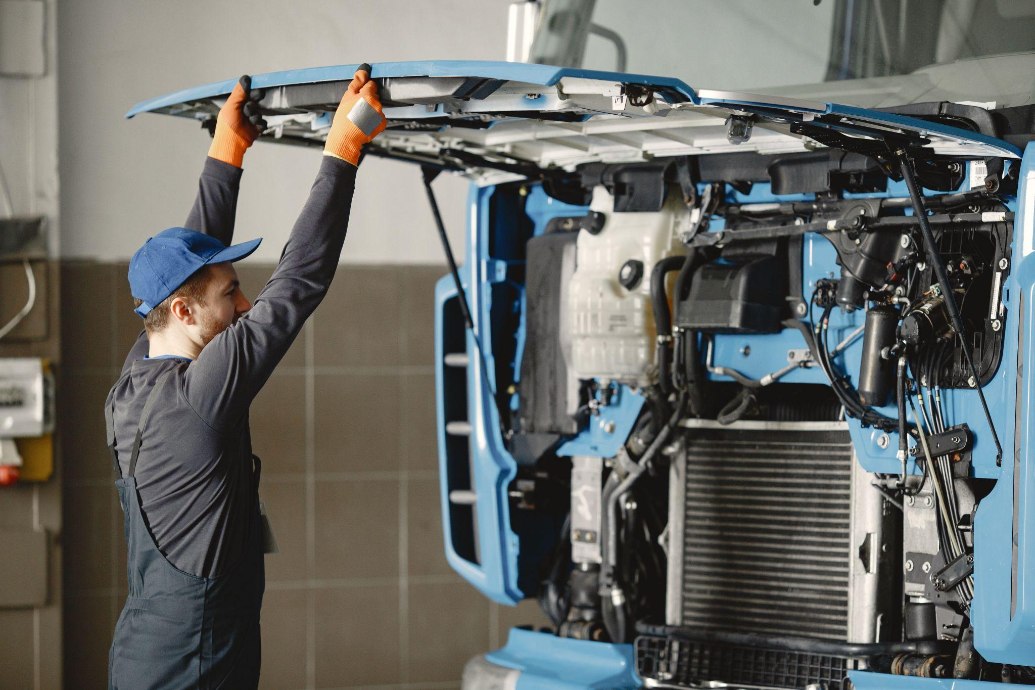 A man inspecting a truck engine